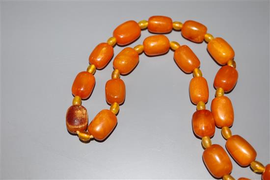 A single strand barrel shaped amber bead necklace, 124cm, gross weight 75 grams.